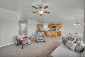 Living room with recessed lighting, a ceiling fan, a chandelier, light tile patterned floors, and light carpet