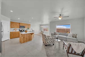 Living room featuring recessed lighting, a ceiling fan, light tile patterned flooring, and a chandelier