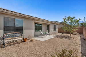 Back of property featuring stucco siding, a fenced backyard, and a patio
