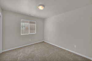 Spare room featuring carpet and baseboards