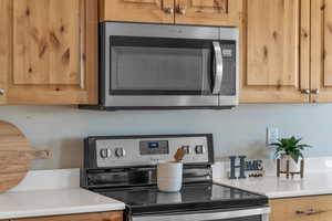 Kitchen featuring appliances with stainless steel finishes and light countertops