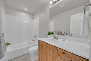 Full bath featuring vanity, shower / bathtub combination, and tile patterned floors