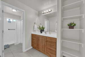 Bathroom featuring vanity, tile patterned flooring, and a shower with curtain