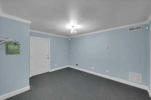 Spare room with dark carpet and ornamental molding