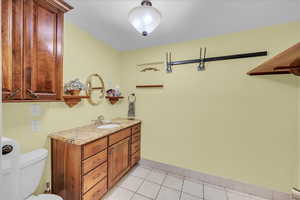Half bath with light tile patterned floors and vanity