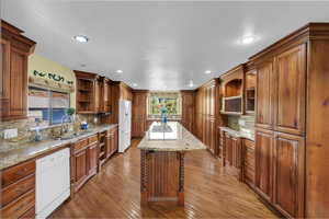 Kitchen with open shelves, brown cabinets, decorative backsplash, and recessed lighting