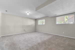 Carpeted empty room featuring a textured ceiling