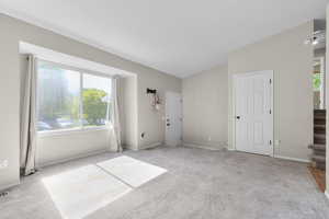 Unfurnished bedroom with light colored carpet and baseboards
