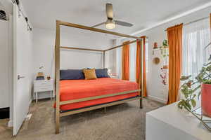 Carpeted bedroom featuring a ceiling fan and baseboards
