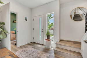Entryway with stairs and wood finished floors