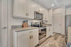Kitchen featuring stainless steel appliances, light wood finished floors, light countertops, and recessed lighting