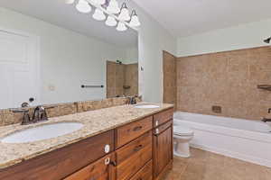 Full bath featuring double vanity, shower / bathtub combination, and tile patterned flooring