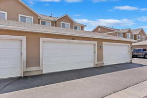 View of front of house featuring stucco siding and community garages