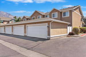 Traditional-style home with stucco siding and community garages