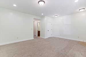 Spare room with light colored carpet and recessed lighting