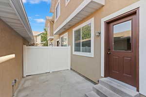 View of exterior entry featuring stucco siding and a patio area