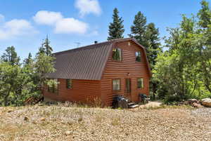 View of home's exterior featuring a gambrel roof and a metal roof