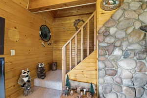 Stairs with wood walls and vaulted ceiling