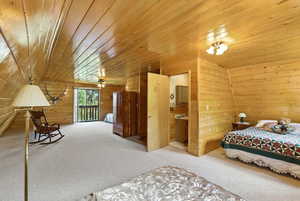 Carpeted bedroom with wood ceiling, access to exterior, and wood walls