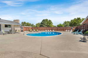 Community pool featuring a patio and a fenced backyard