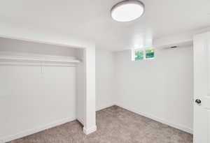 Basement featuring light colored carpet and baseboards