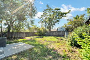 Fenced backyard featuring a patio area and a storage unit