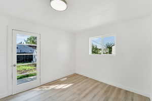 Unfurnished room with light wood-style floors and baseboards