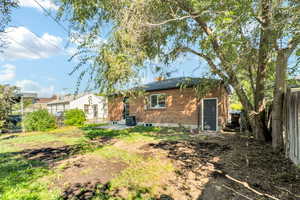 Rear view of house featuring a patio area, brick siding, and a chimney