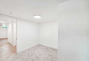 Below grade area featuring baseboards and light carpet