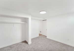 Unfurnished bedroom with light carpet and a closet