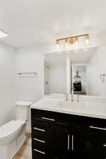 Full bathroom with vanity, light wood finished floors, and a textured ceiling