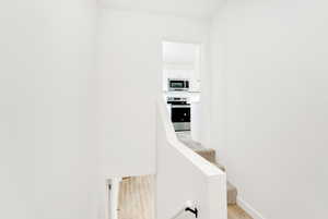 Hall featuring light wood-type flooring and baseboards