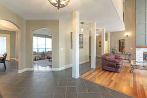 Living room featuring arched walkways, a fireplace, and dark wood-type flooring