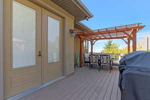Back deck featuring grilling area, a pergola, outdoor dining area, and french doors