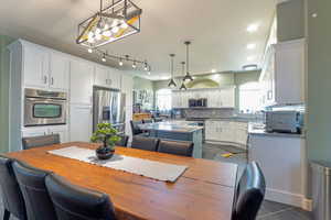 Dining space with healthy amount of natural light, dark tile patterned flooring, and recessed lighting