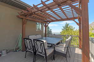 Deck with a pergola and outdoor dining space