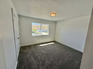 bedroom with dark carpet and a textured ceiling