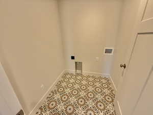 Washroom featuring hookup for a washing machine and light tile patterned floors