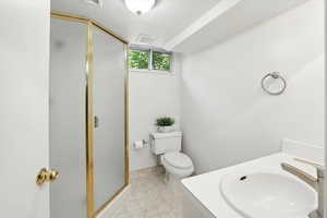 Full bathroom with a textured ceiling, a shower stall, and vanity
