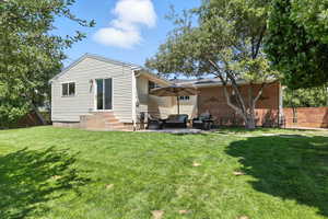 Rear view of property with entry steps, an outdoor hangout area, and a patio