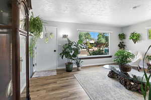 Living area featuring a textured ceiling and wood finished floors