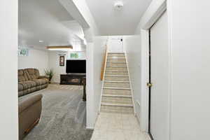 Stairs featuring a textured ceiling and carpet