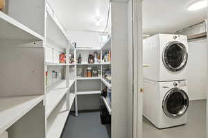 Laundry area featuring stacked washing machine and dryer