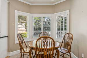 Dining space with ornamental molding and baseboards