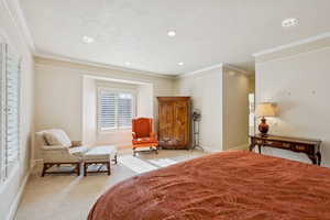 Bedroom with light carpet, ornamental molding, a textured ceiling, and recessed lighting