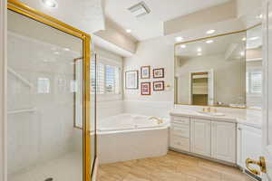 Full bath featuring a garden tub, vanity, a shower stall, and recessed lighting