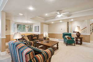 Living room with crown molding, a textured ceiling, carpet, recessed lighting, and ceiling fan