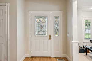 Entryway with light wood finished floors and baseboards