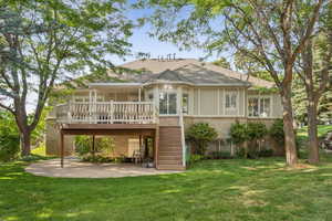 Rear view of property featuring brick siding, a yard, and stairway