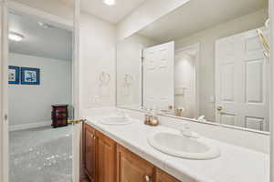 Full bath featuring double vanity and baseboards